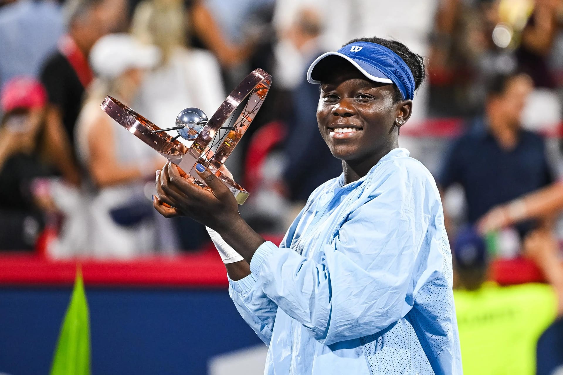 Aug 7, 2025; Montreal, QC, Canada; Victoria Mboko (CAN) tournament winner against Naomi Osaka (JPN) holds her trophy at IGA Stadium. Mboko rose 61 places in the WTA rankings to a career-high world No. 24 and how has $1.2M in career earnings after winning her first-ever WTA Tour title in Montreal. Credit: David Kirouac-Imagn Images