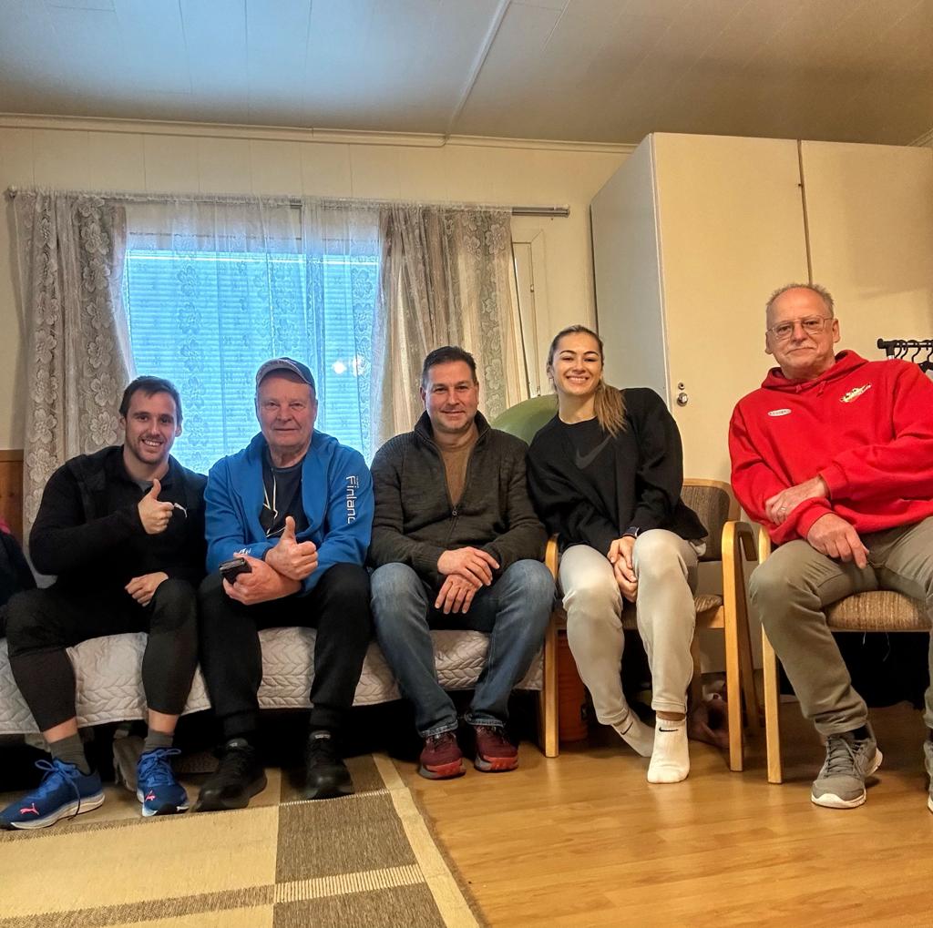 Marija and her coaching team smiling together on a couch