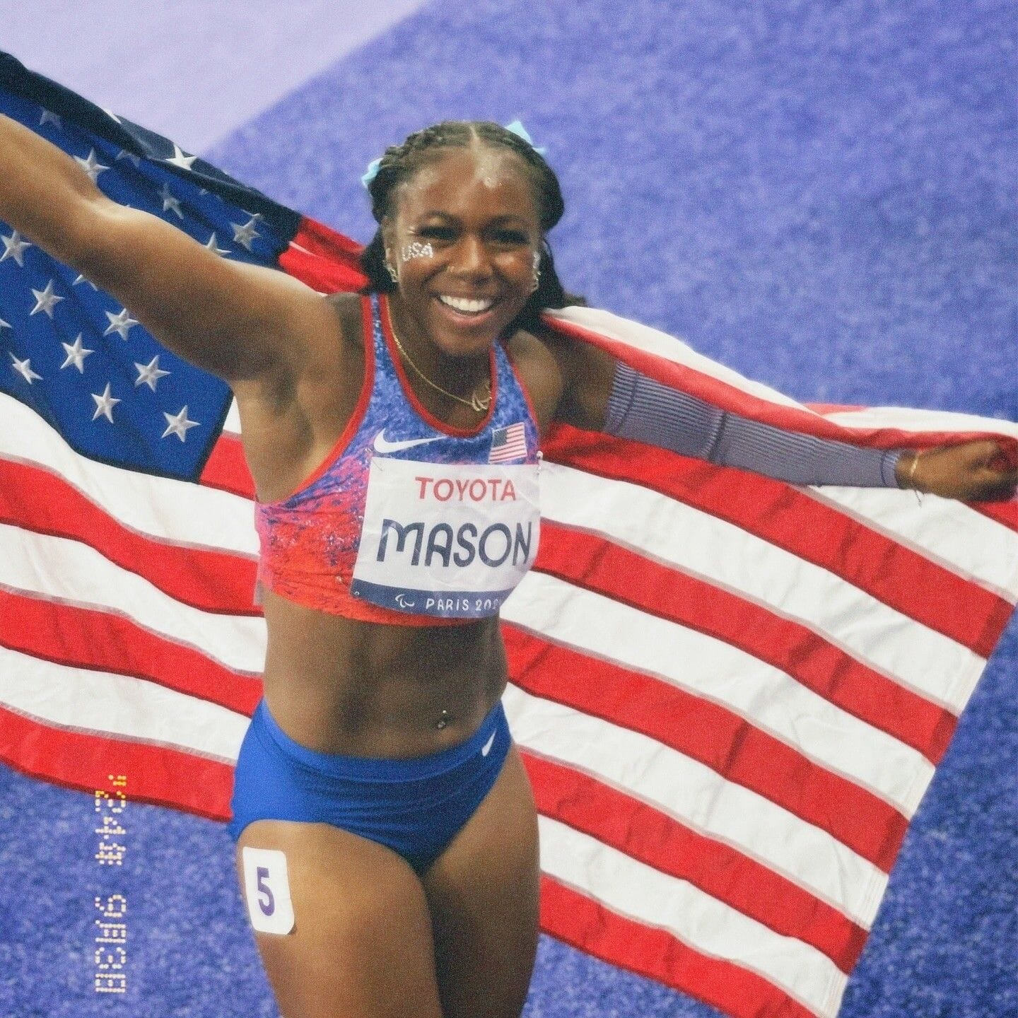 Brittni Mason holds US flag after Paralympic race