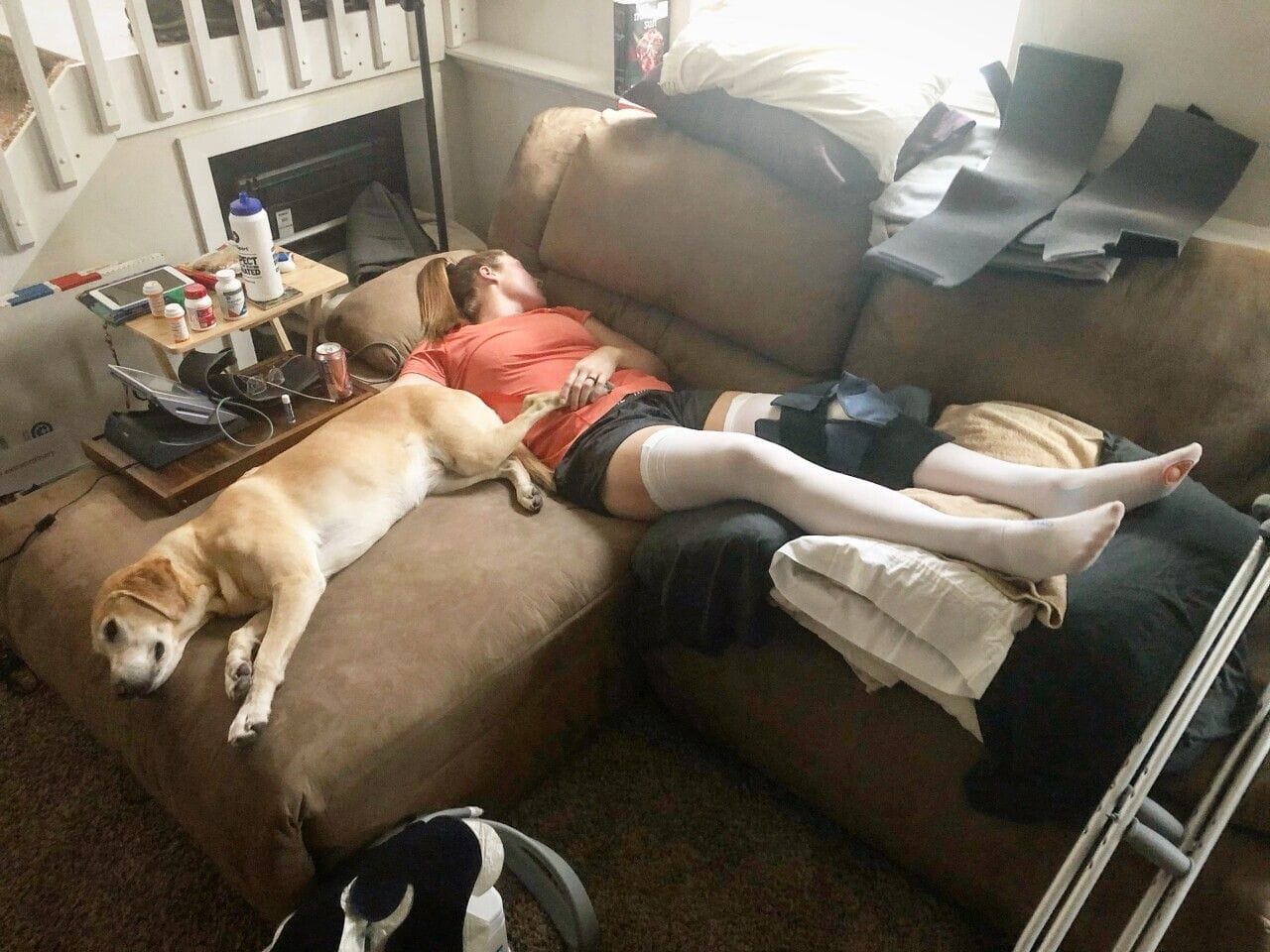 Kara recovering from injury on the couch with her dog
