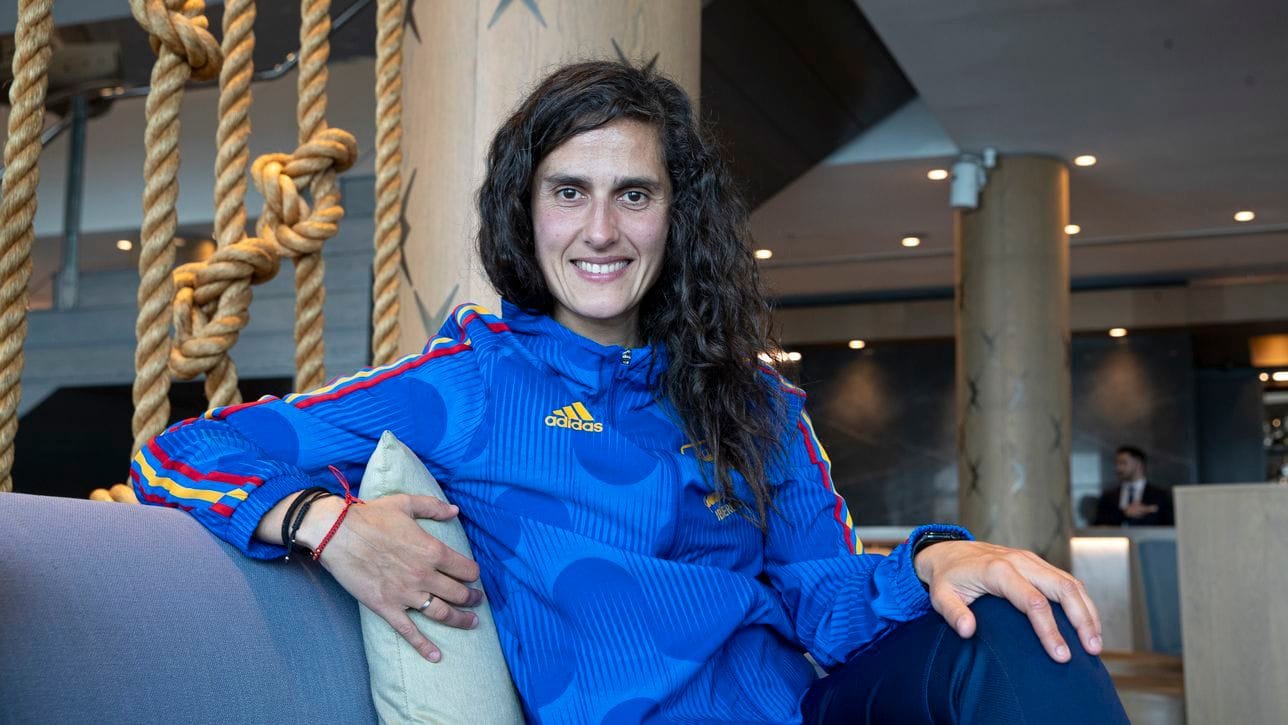 Montse Tomé smiles in a Spain soccer jacket