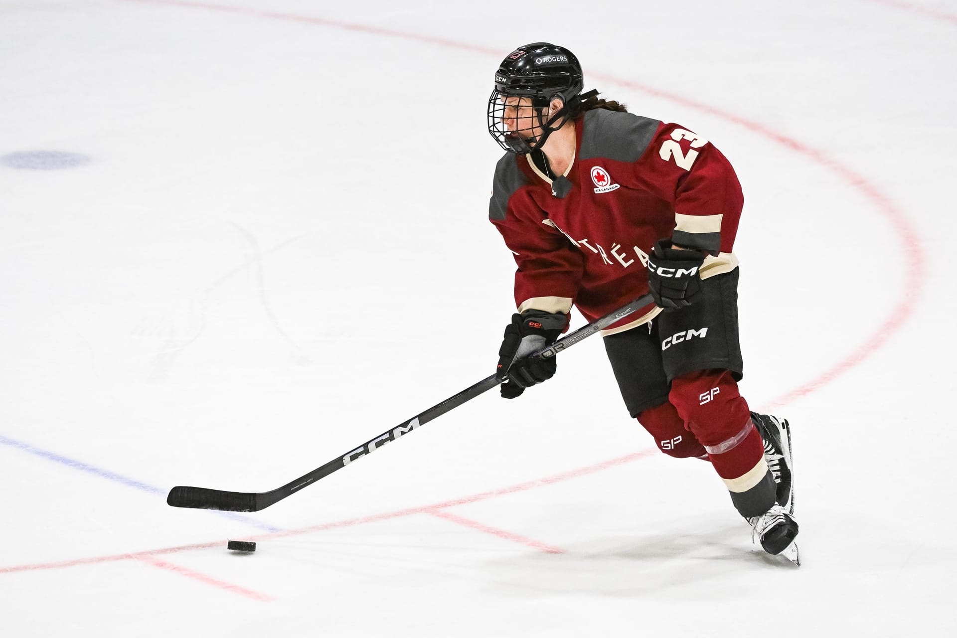 Jan 13, 2024; Montreal, Quebec, CANADA; Montreal defender Erin Ambrose (23) plays the puck against Boston during the second period in a PWHL ice hockey game at Verdun Auditorium. Credit: David Kirouac-Imagn Images
