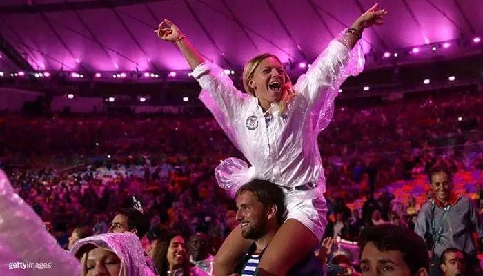 Morghan sitting on a man's shoulders in an Olympic arena cheering