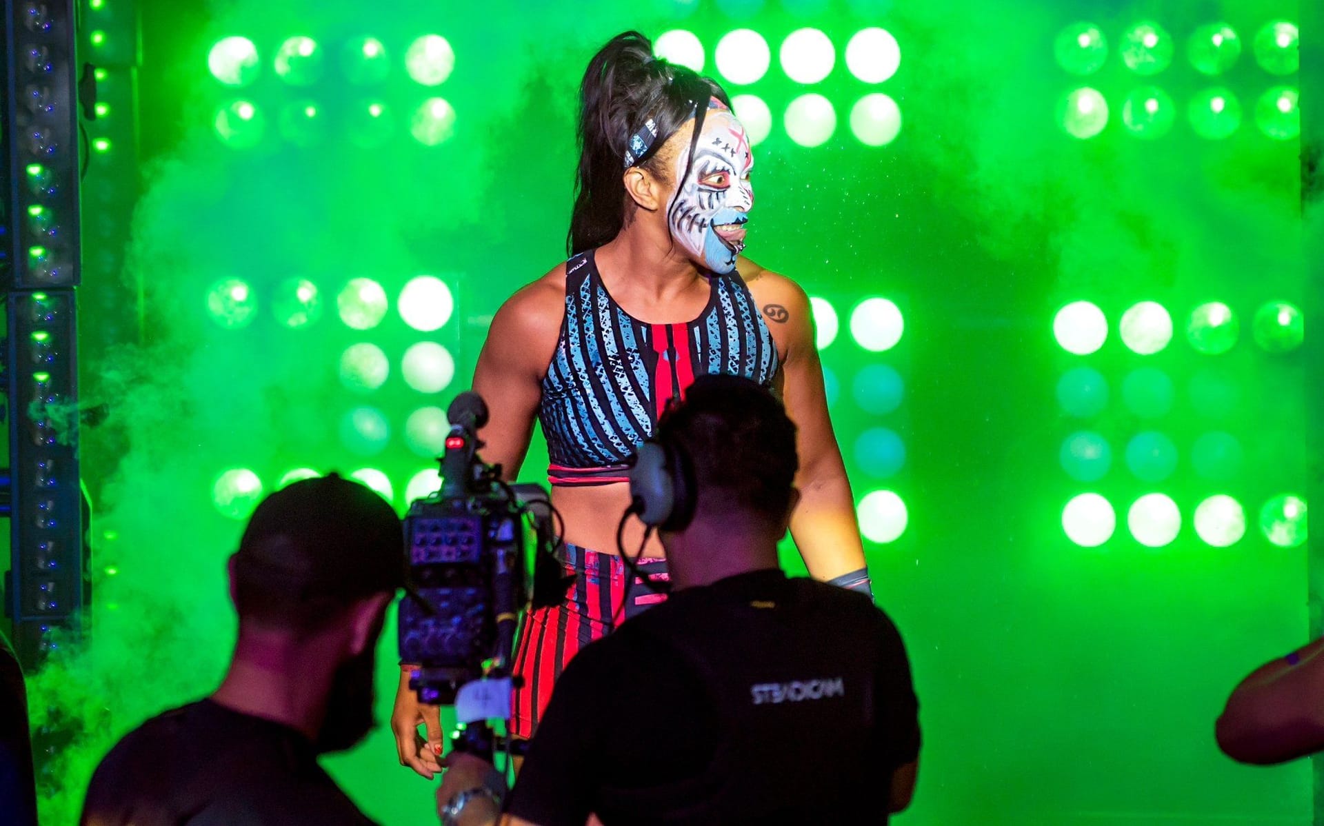 Camille on greenlit and foggy stage in costume and facepaint