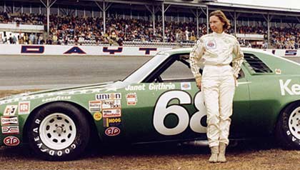 Janet Guthrie stands with her racecar at the Daytona track