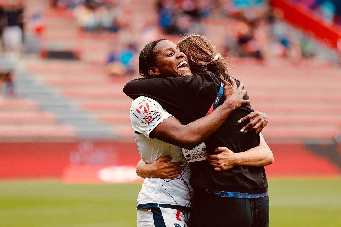 Naya and a teammate embrace on the field
